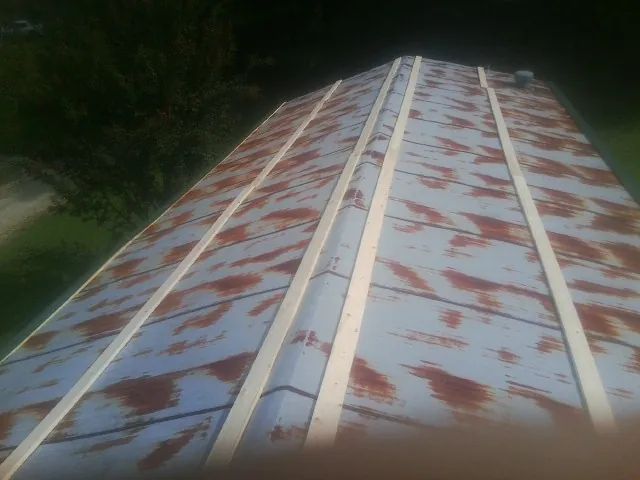 Rusted metal roof panels with new wood purlins before replacement — Storm Damage Roof Repair in Scandinavia by Roofing Brothers