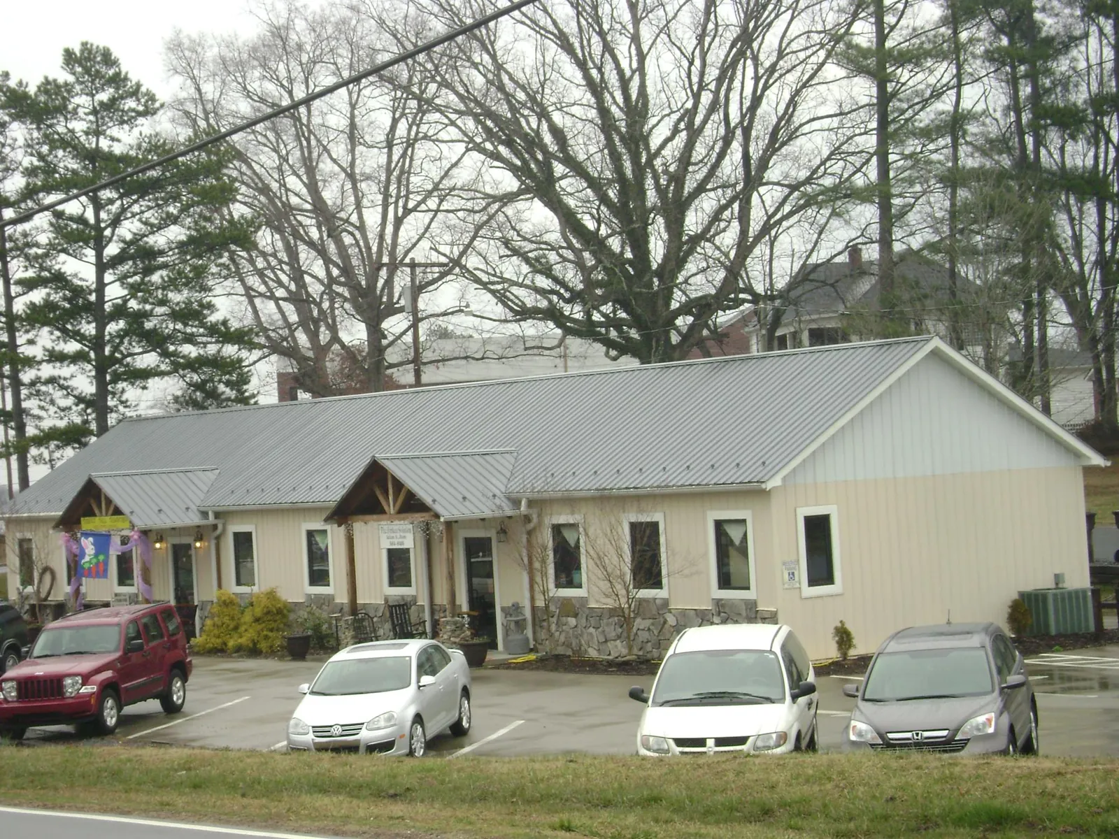 Gray metal roof with timber entry brackets on a small commercial building in Scandinavia