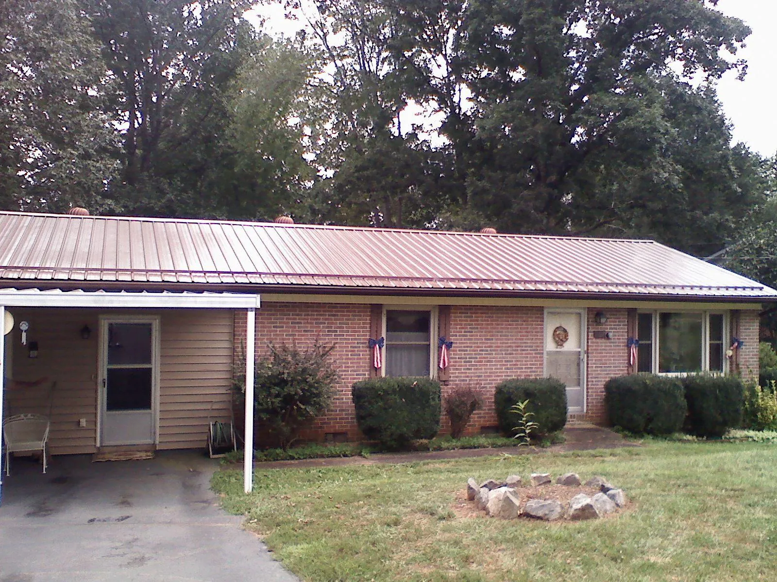 Bronze metal roof and carport on a brick ranch home — Roof Repair work by our crew in Scandinavia