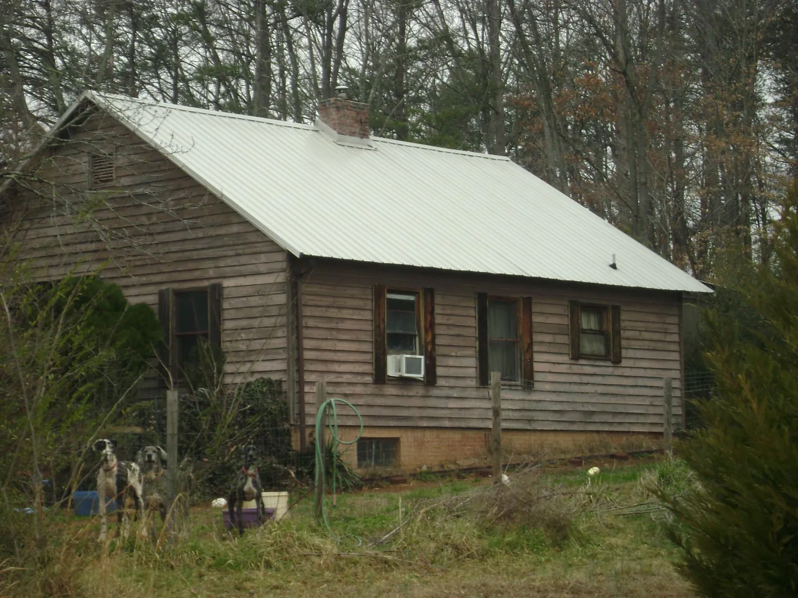 White metal roof on an old wood sided farmhouse, from a Metal Roof Installation job in Scandinavia